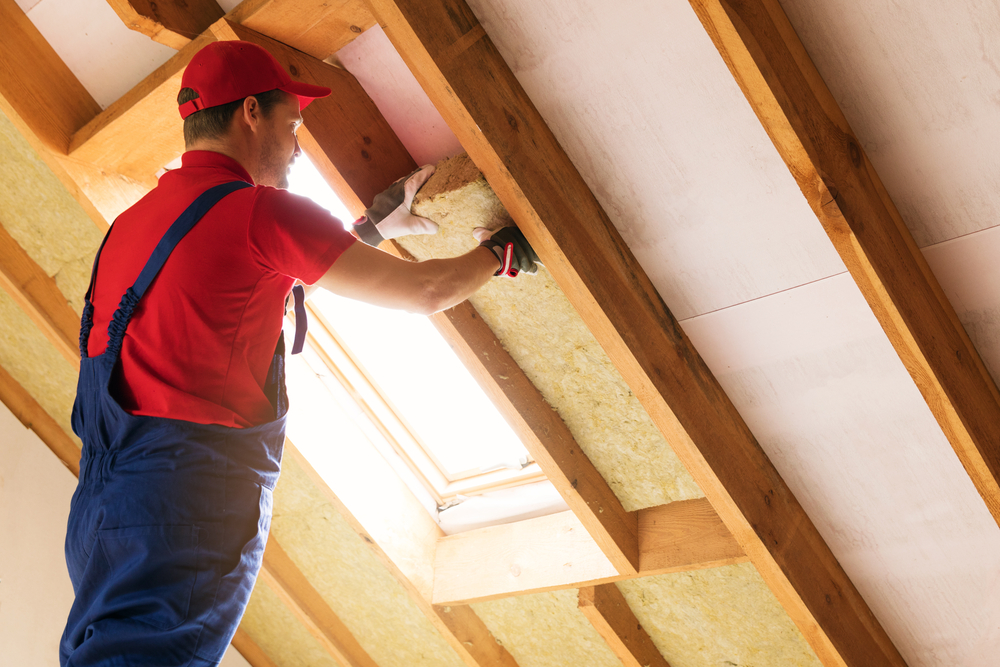 Worker installing roof insulation in a Richmond, VA attic.